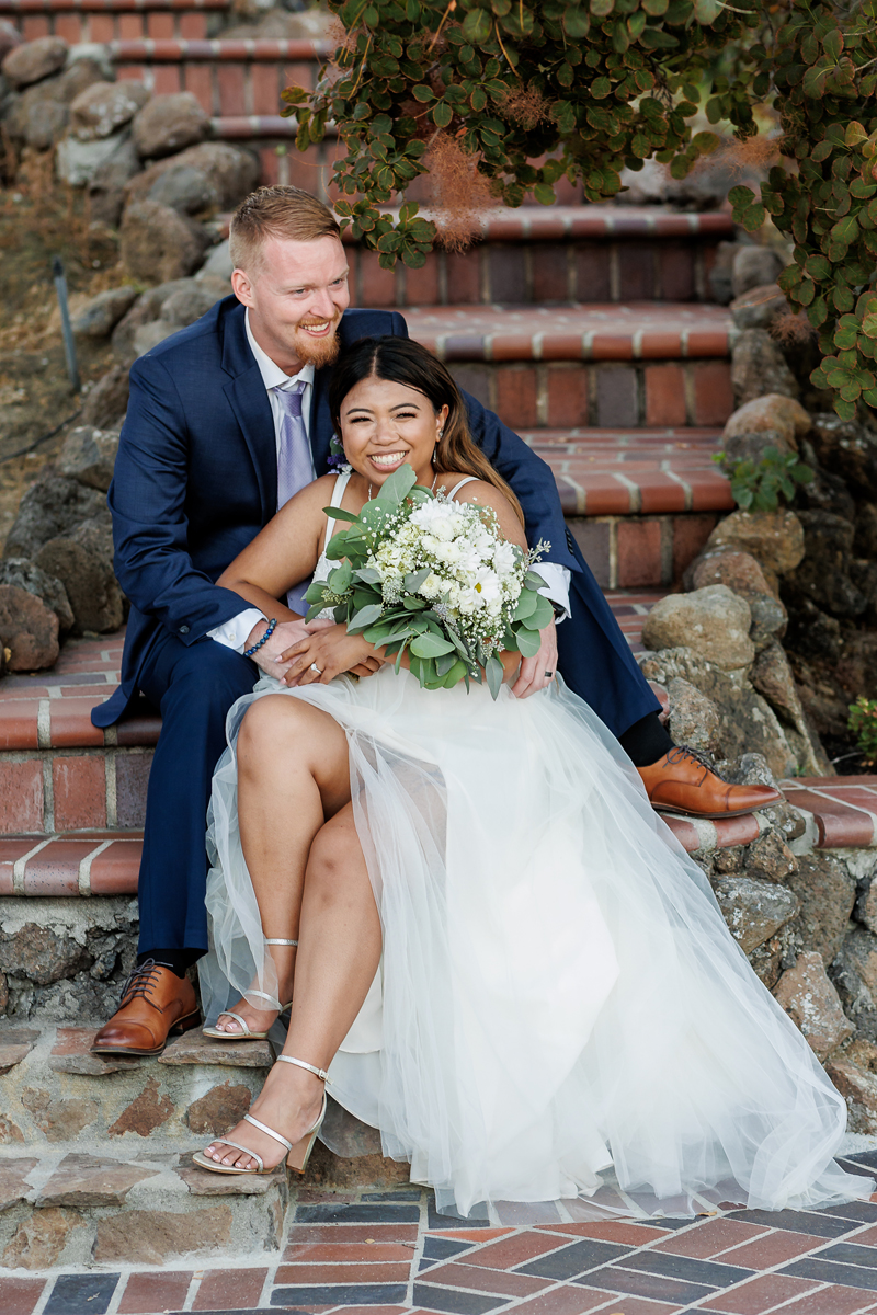 bride and groom laughing on stairs at Bhachu Vineyards during their San Francisco Bay Area vineyard wedding