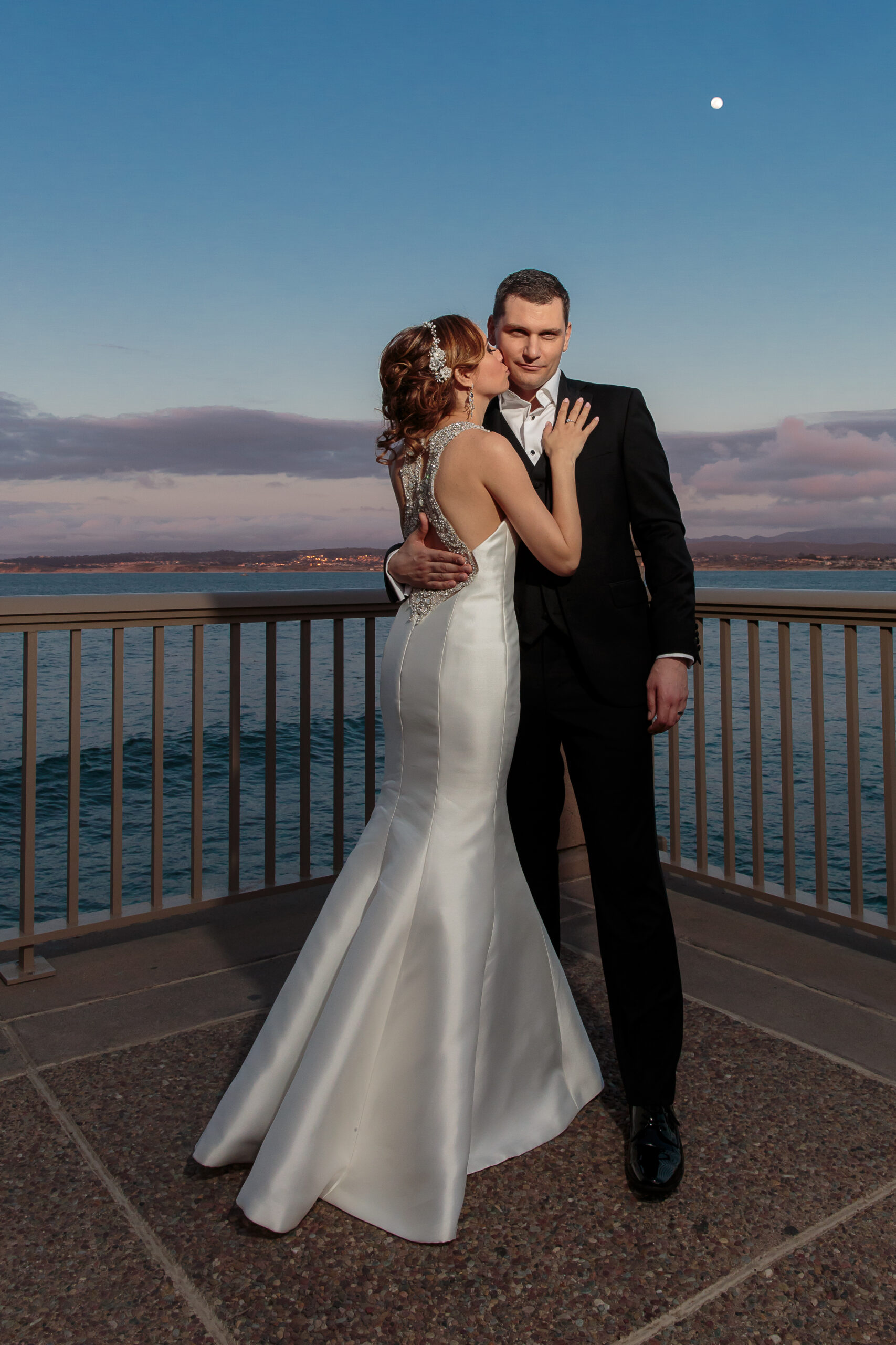 stunning bride and groom wedding photo under the full moon during blue hour at Monterey Plaza Hotel & Spa in California