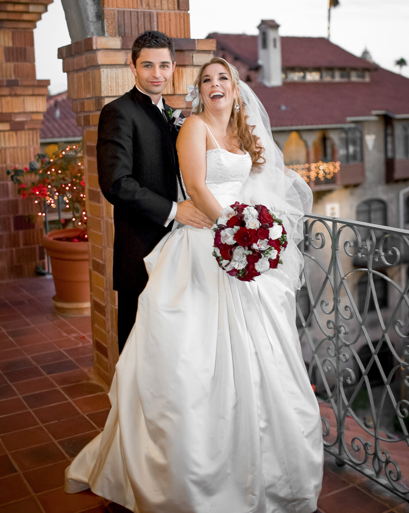bride and groom enjoying a romantic moment on the balcony at Mission Inn Riverside wedding photography