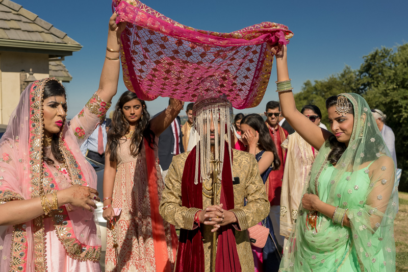 Indian groom walking out of house dressed for wedding ceremony in Sacramento California on his wedding day