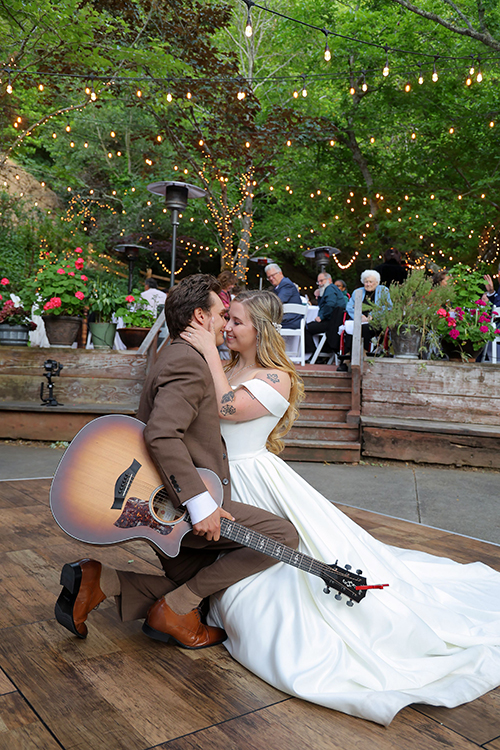 groom serenading his bride by playing guitar on the dance floor during their wedding reception at Wildwood Acres in Lafayette, California