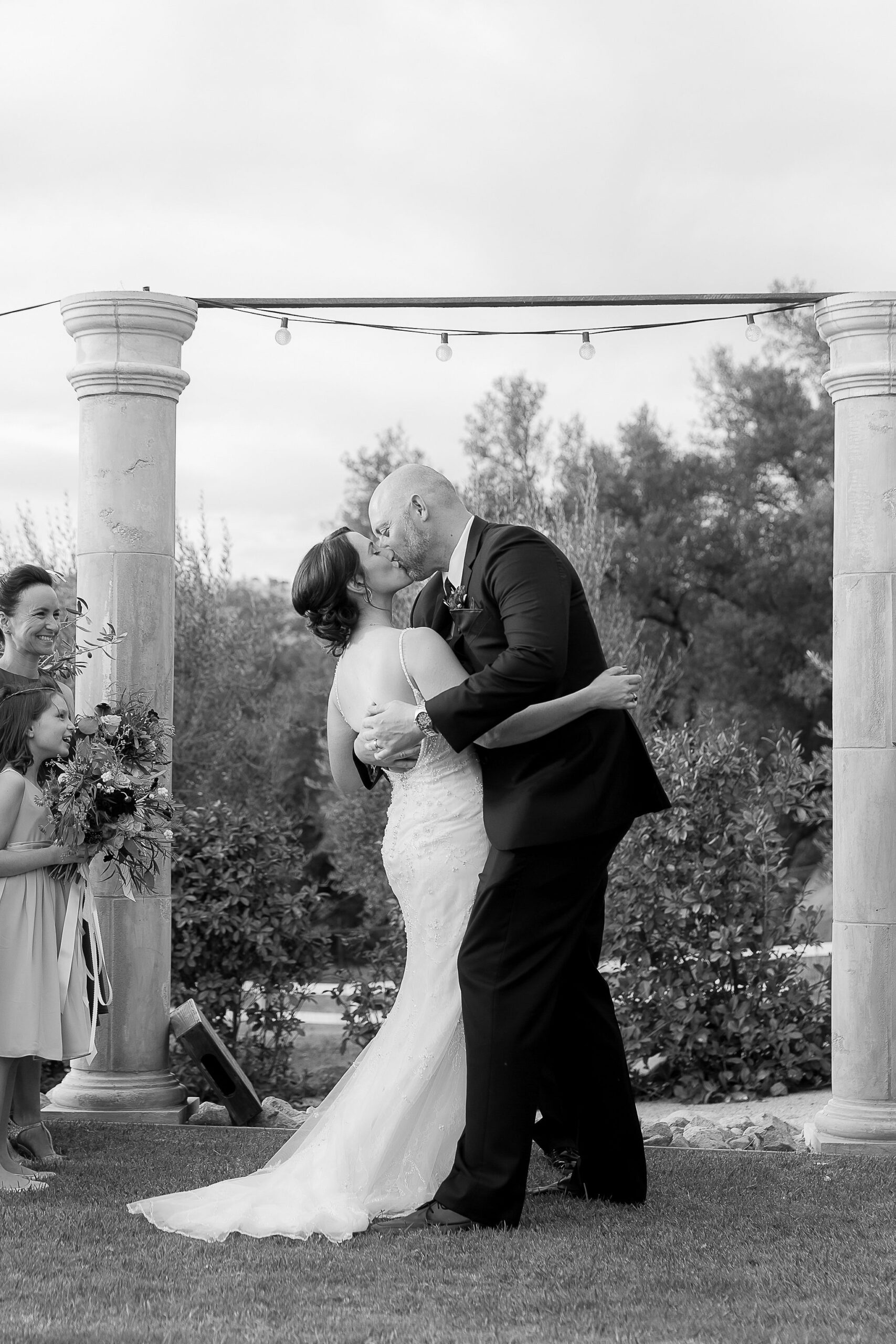 Bride and groom sharing their first kiss at Hidden Grove wedding in Woodland California