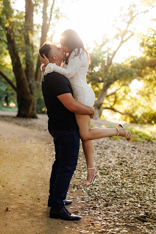 couple embracing at sunset in the gardens of uc davis arboretum during their engagement session