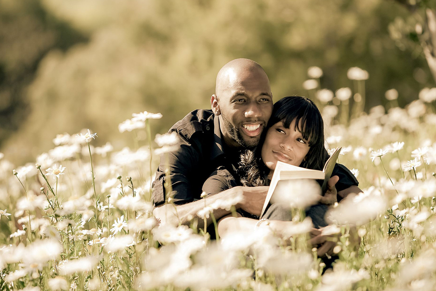 engagement photography couple sharing a quiet moment reading a book together in a garden setting at uc davis arboretum