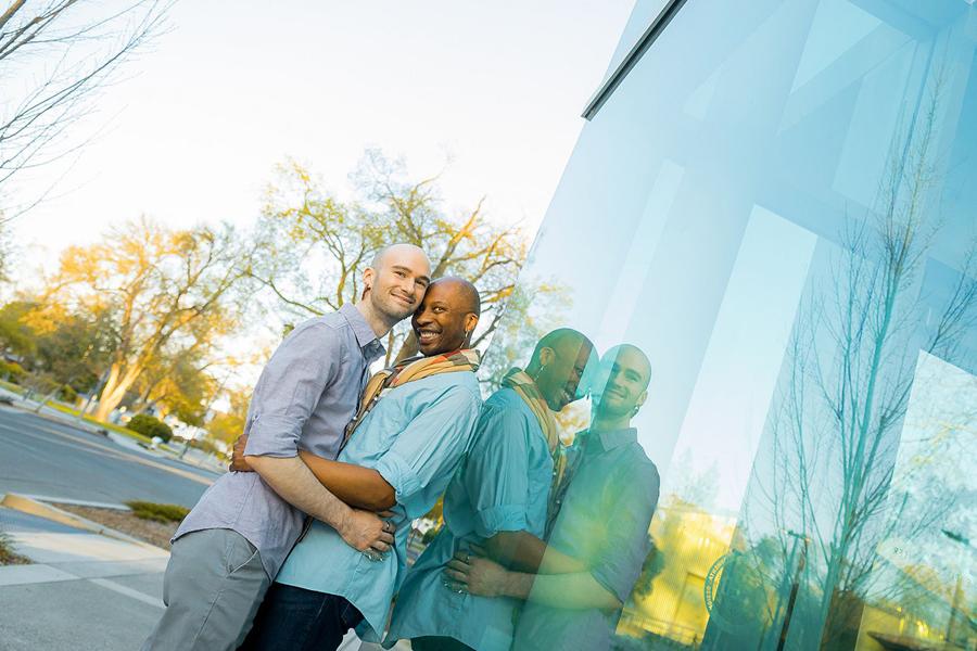 romantic lgbtq couple enjoying a poetic moment together on the grass with a rose during sacramento engagement session