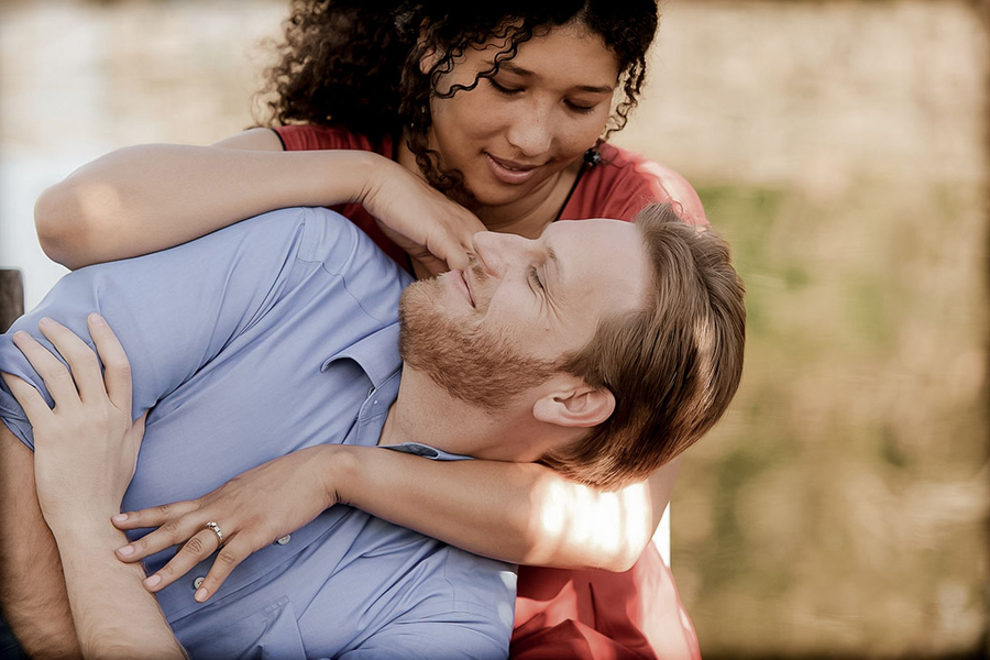 couple in love laughing together during a romantic engagement session at jacuzzi winery in napa valley
