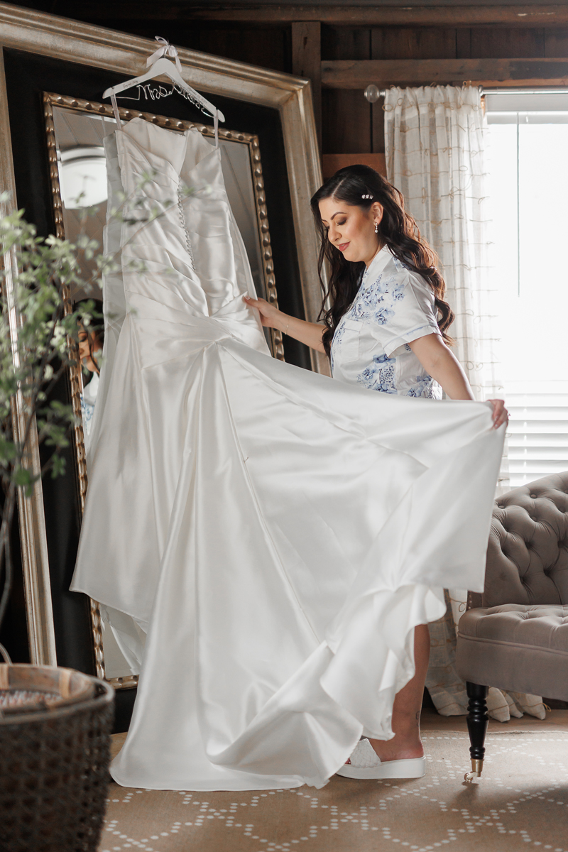 bride admiring her wedding dress at The Barns at Cooper Molera in Monterey, California during her wedding day preparations