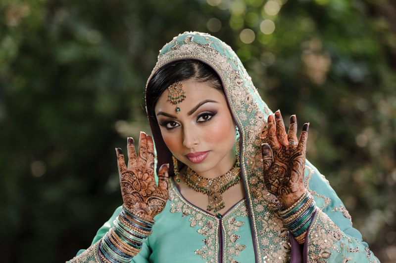Elegant Pakistani bride displaying intricate henna designs on her hands during wedding preparations in Sacramento