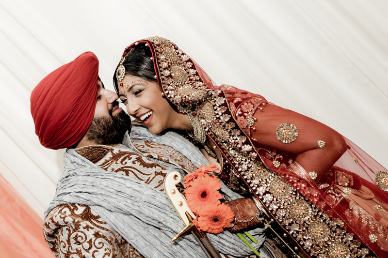 Fun bride and groom portrait taken at Gurdwara Sahib West Sacramento during their Sikh wedding celebration