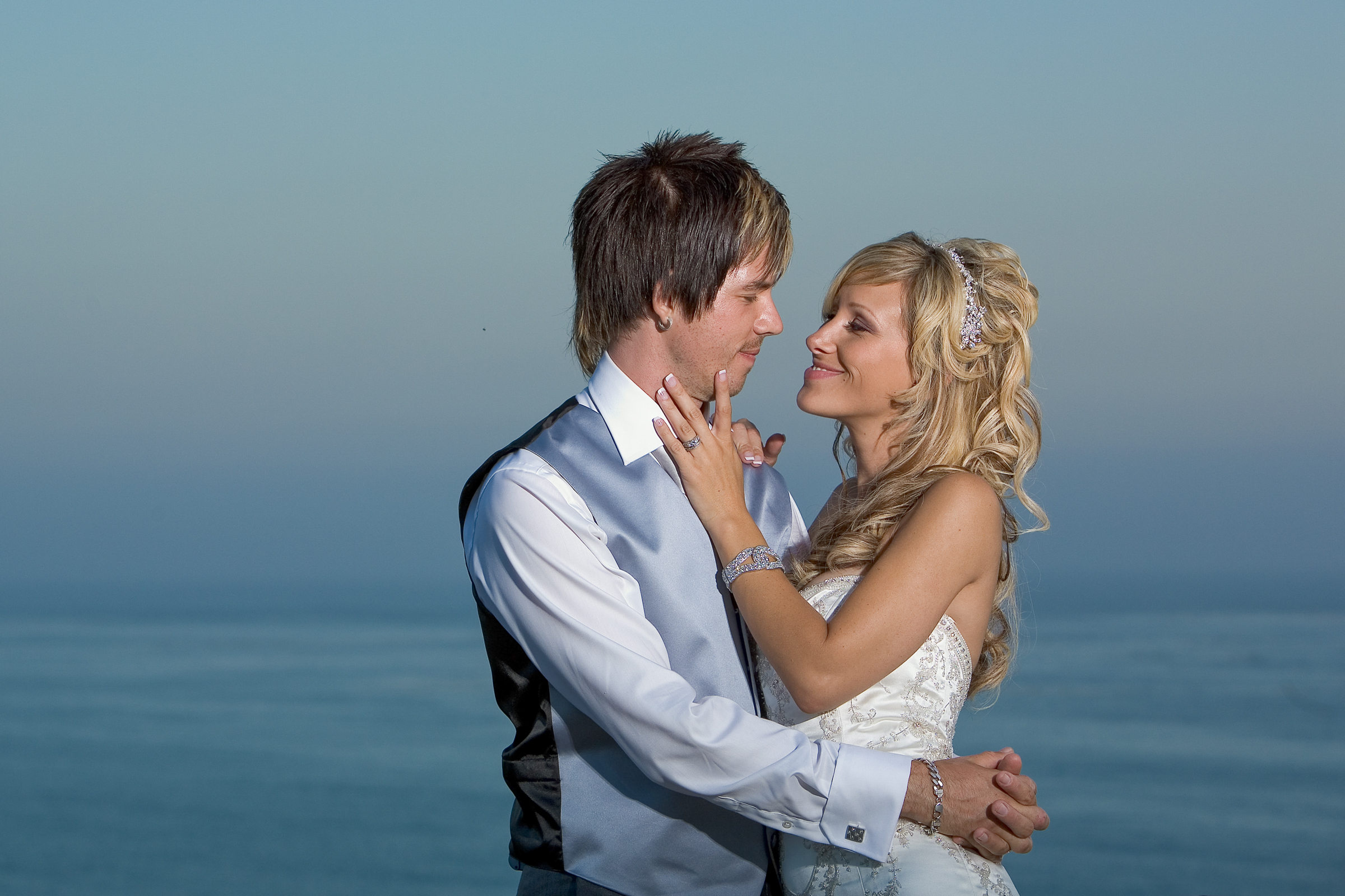 bride and groom standing on bluff at Baker Beach during sunset in San Francisco, California