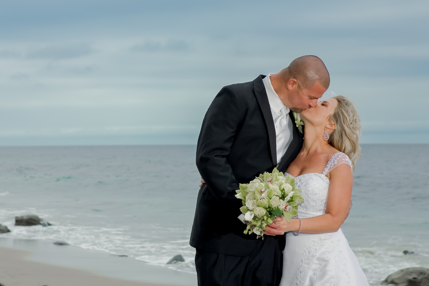 Bride and groom sharing a romantic kiss at Baker Beach in San Francisco