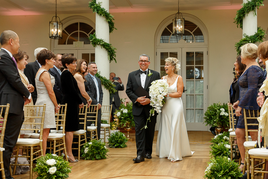 bride walking down the aisle during her wedding ceremony at The University Club in San Francisco, California