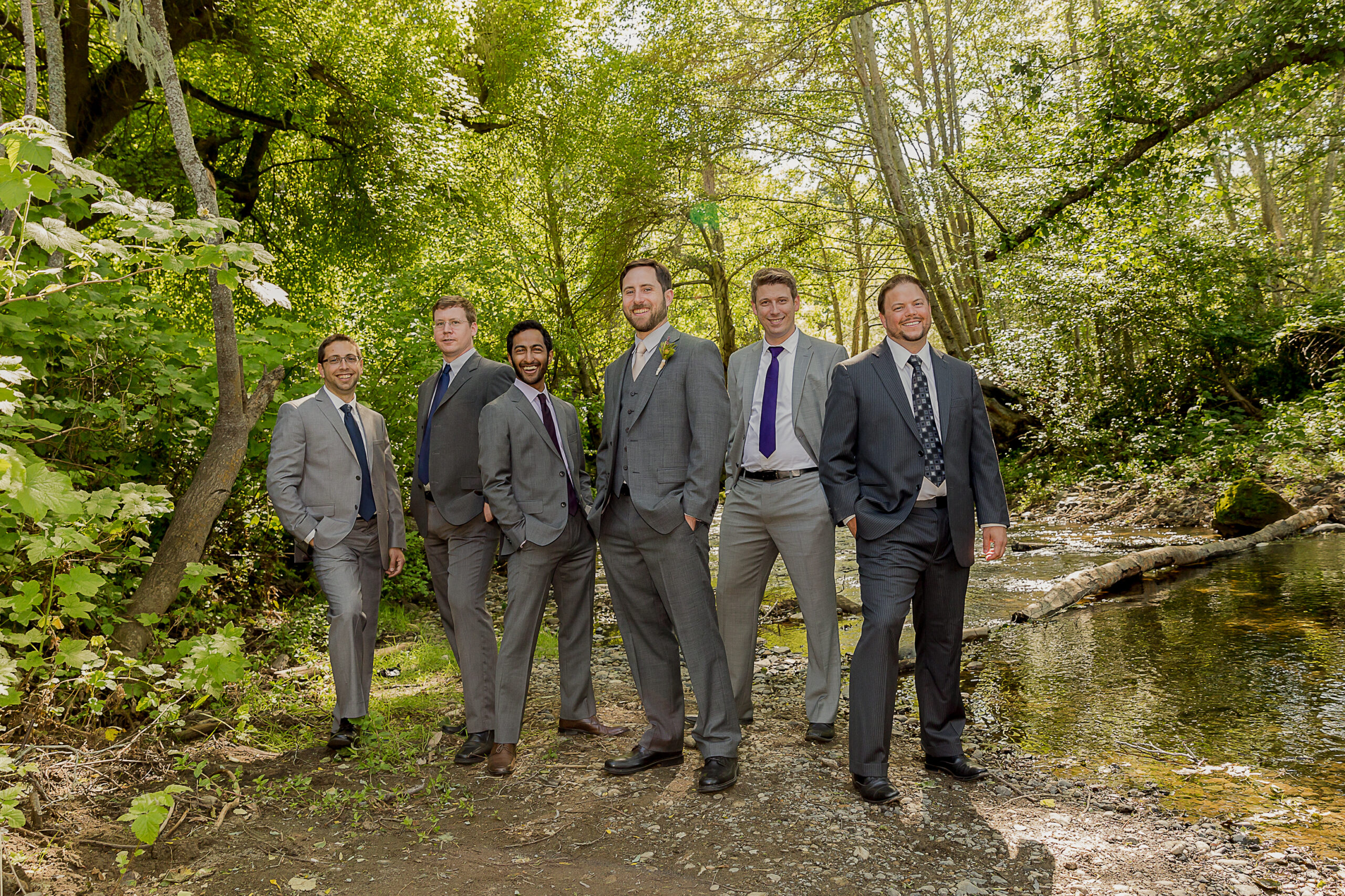 stylish groom and groomsmen standing by the river at Ralston White Retreat, captured by professional wedding photography