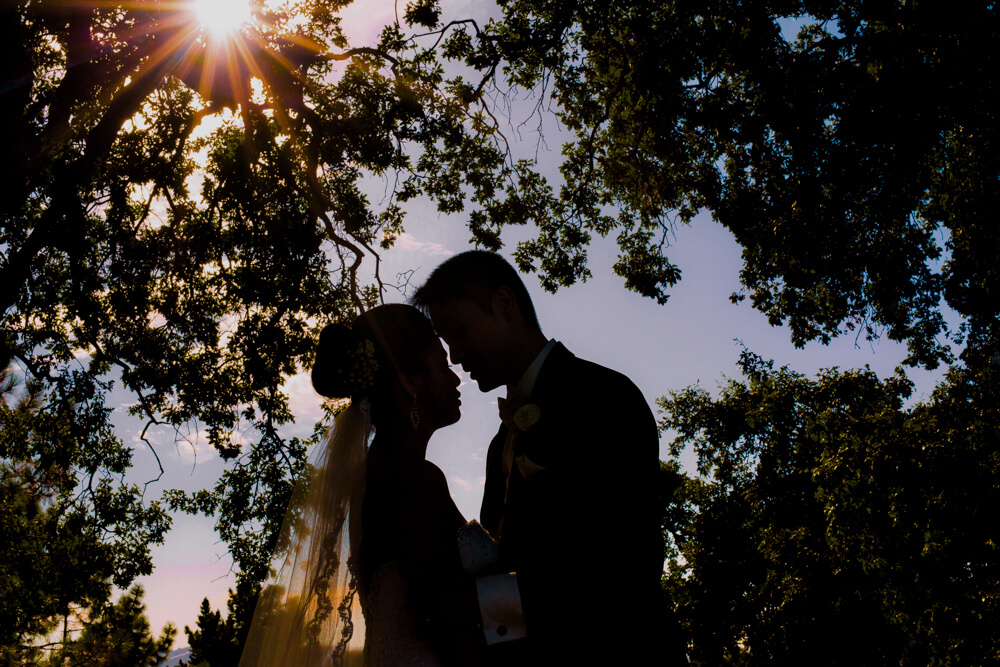 Bride and groom silhouetted against a dramatic sunset at Boundary Oak Golf Course during their wedding day.