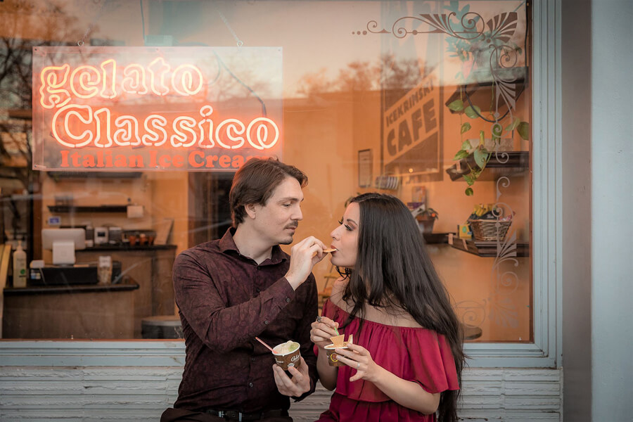 Couple sharing gelato in downtown Davis, playful candid engagement moment with soft natural light and relaxed feel