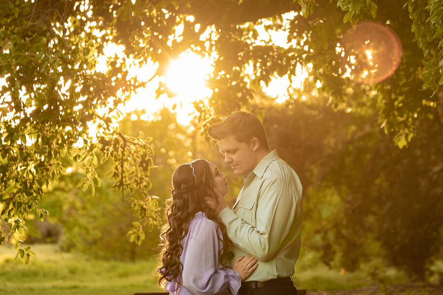 Couple at UC Davis Arboretum during sunset, warm golden light and relaxed candid moment among trees and gardens