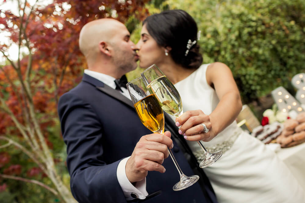 Bride and groom sharing a toast and kiss during wedding celebration at Nestldown in Los Gatos California