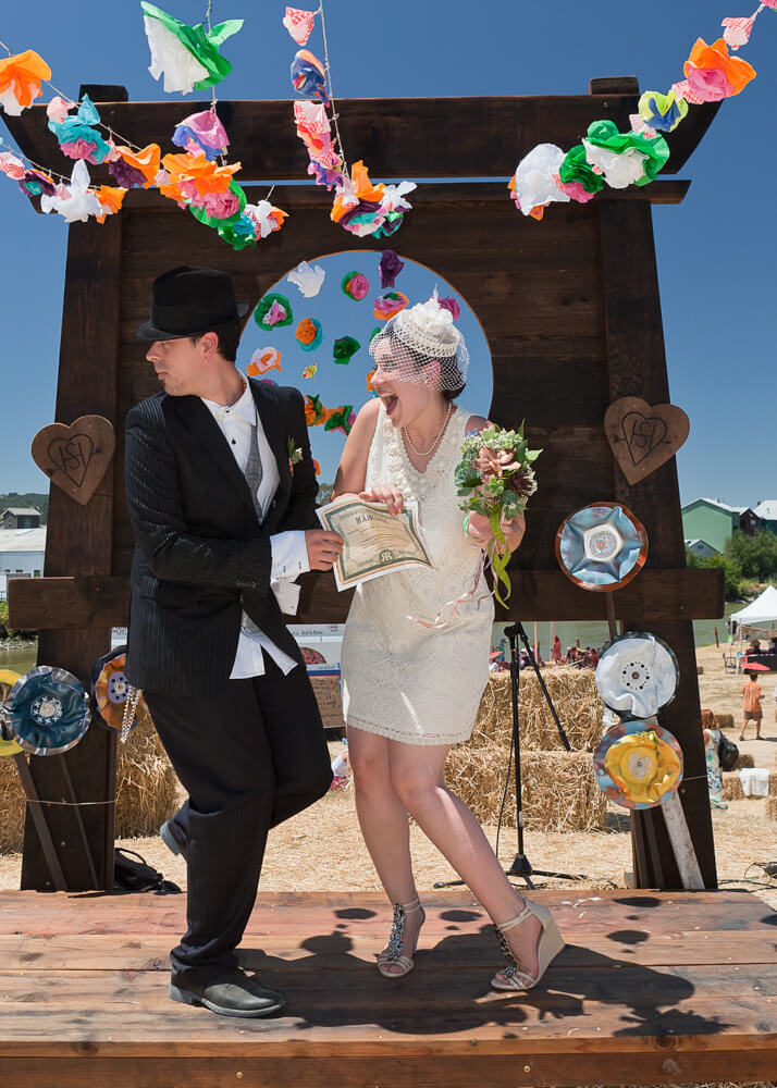 Bride and groom laughing together during playful fairground wedding portrait session