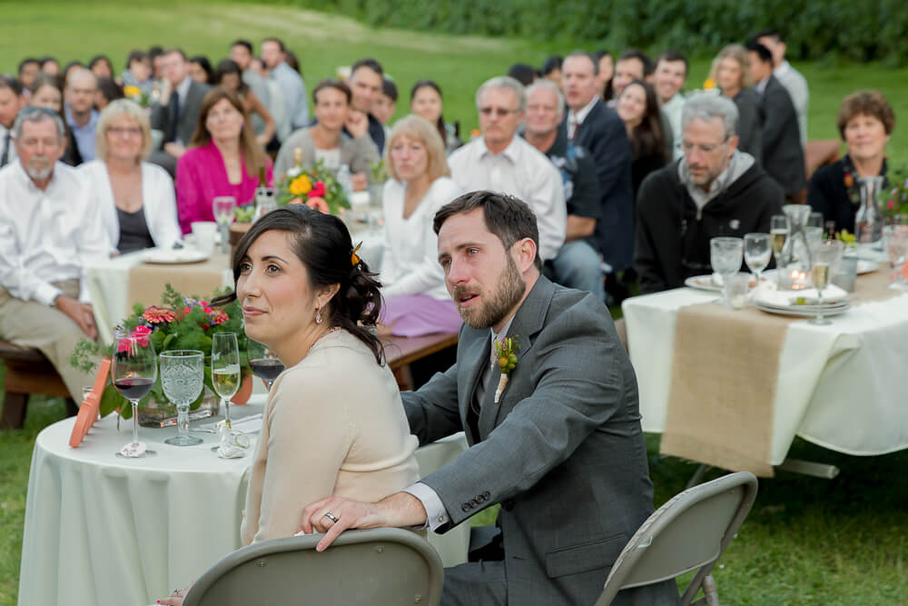 Emotional bride and groom reacting during heartfelt wedding speech at Sacramento wedding reception