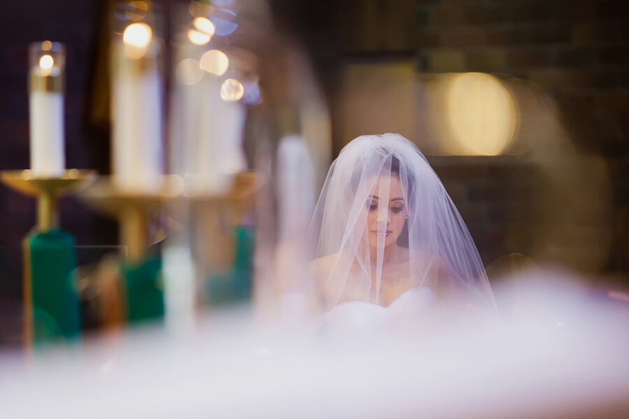 Reflective bridal portrait beside candlelit altar at Cathedral of the Blessed Sacrament in Sacramento