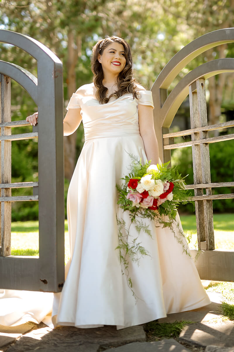 Bride posing by garden gate at Heather Farm