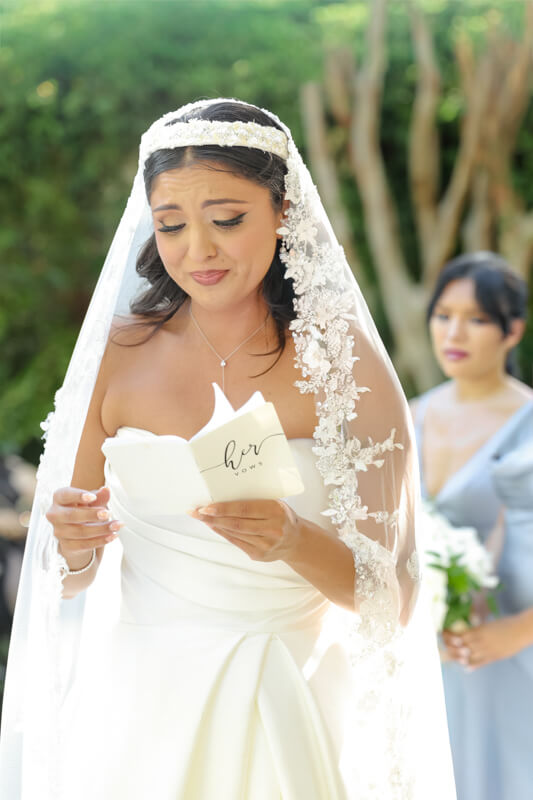 Emotional bride wiping away tears during the wedding vows at Brownstone Gardens